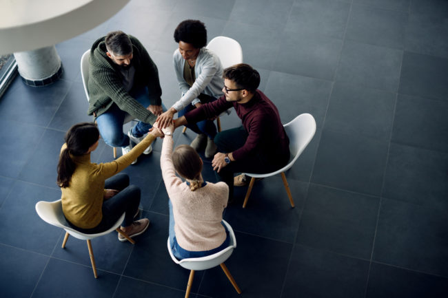 view-group-therapy-participants-holding-hands-unity-during-meeting-scaled-1